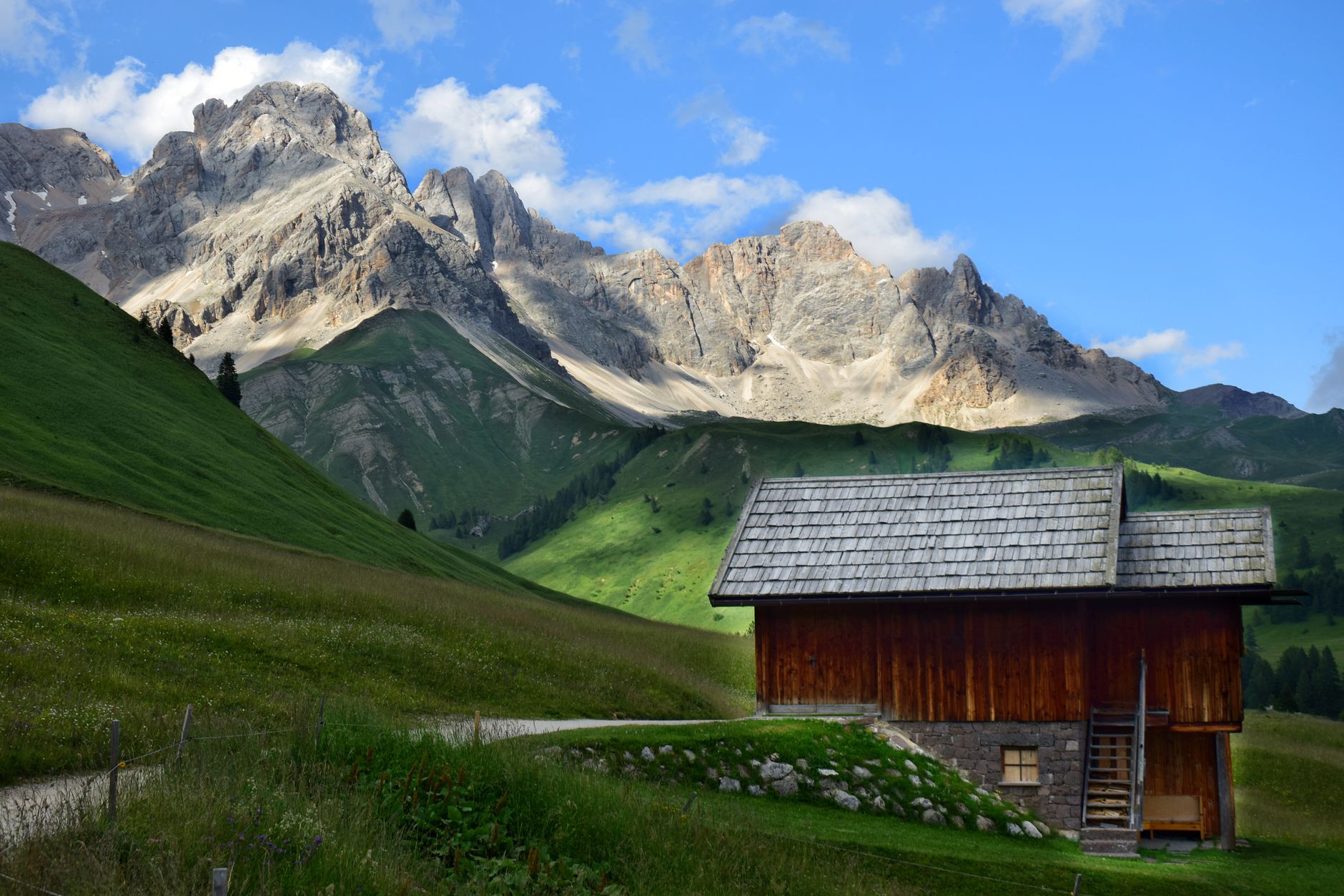 Quiet wooden alpine cabin overlooking limestone peaks in Dolomites